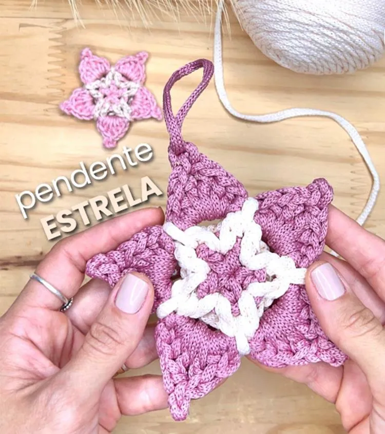 Mãos segurando Estrela de Natal de crochê de cor rosa antigo e pérola