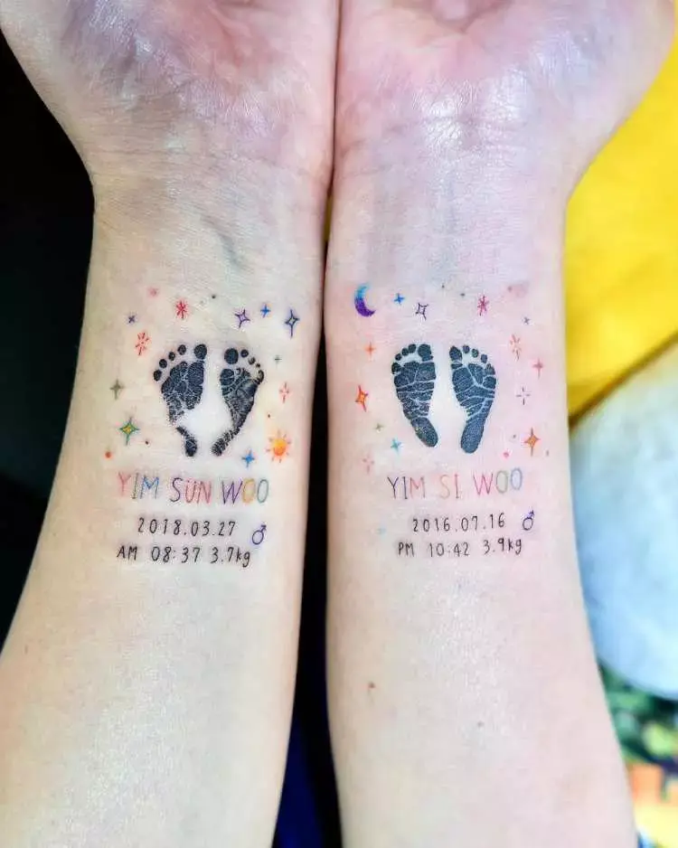 tatuagem nos dois pulsos, cada braço com uma data de nascimento diferente e pés de recém nascido, decorações de brilho ao redor