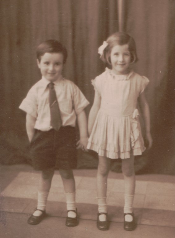 Um casal de irmãos vestido com um exemplo da moda infantil no início do século XX.