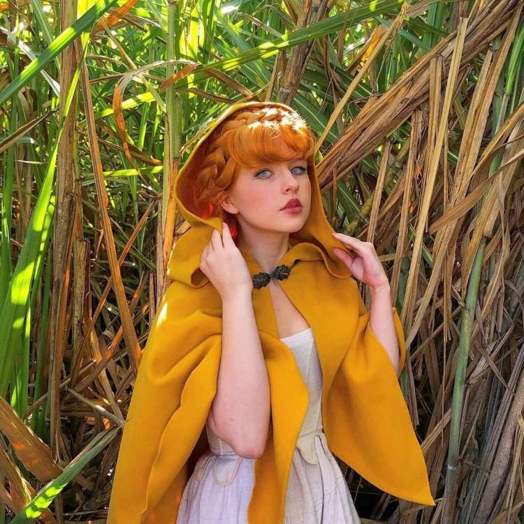 Menina com capa amarela curta de Halloween