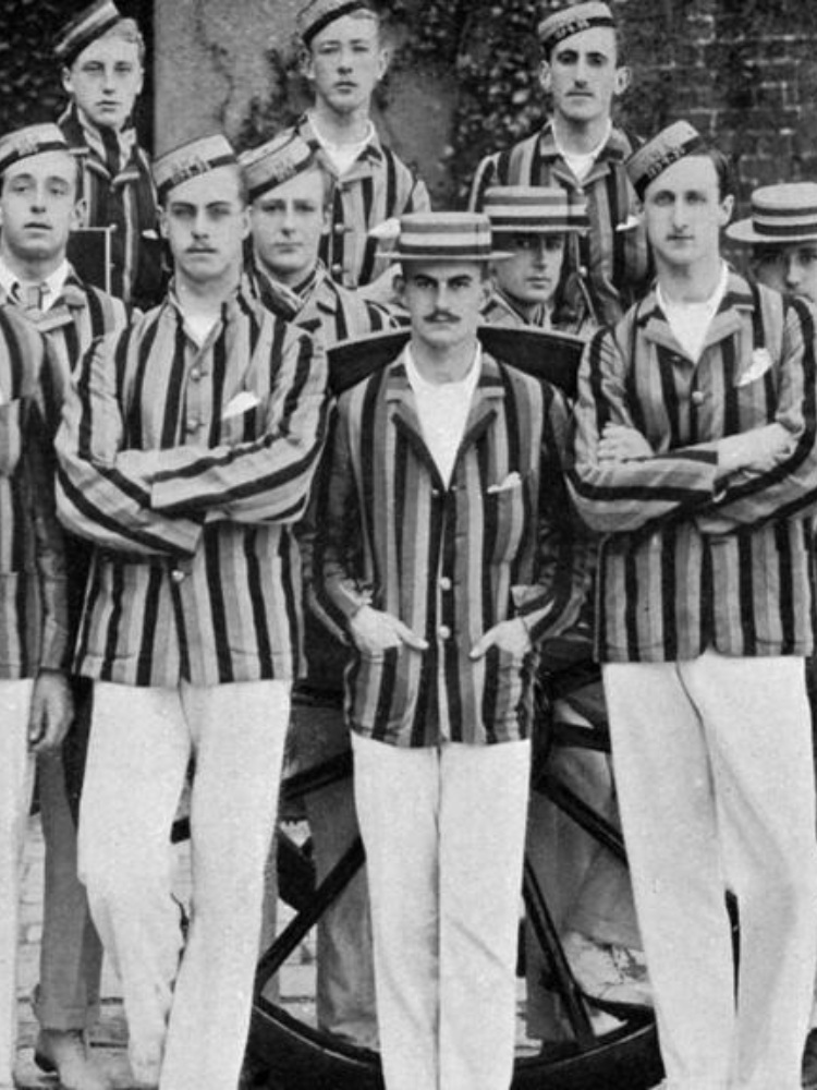 imagem antiga de homens usando blazer listrado com calça branca e chapéu listrado