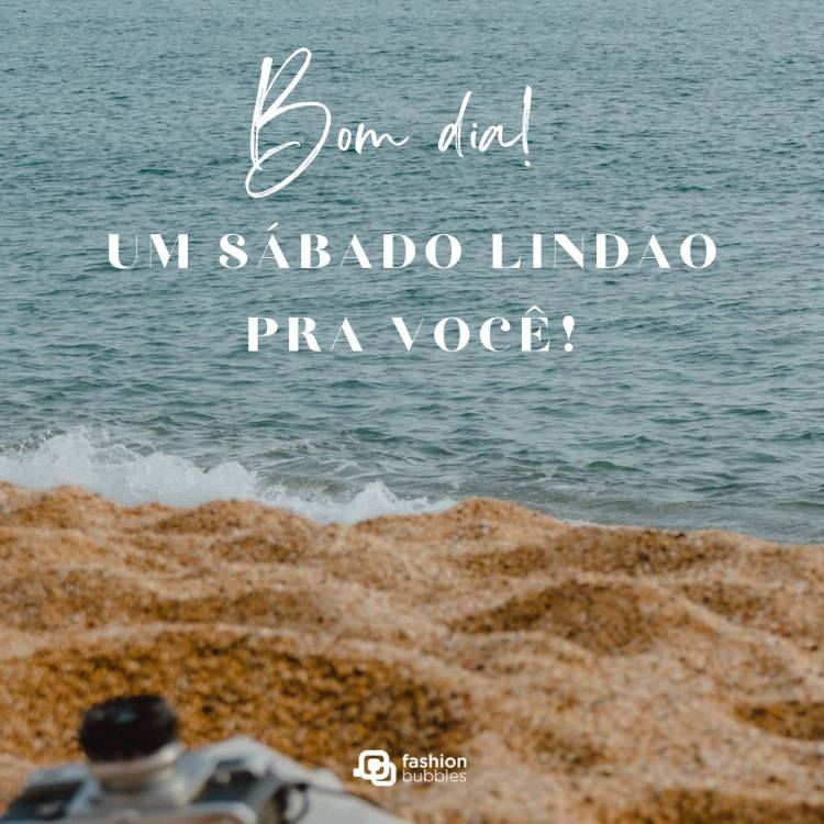 Foto de areia e mar com frase "Bom dia. Um sábado lindão pra você!"