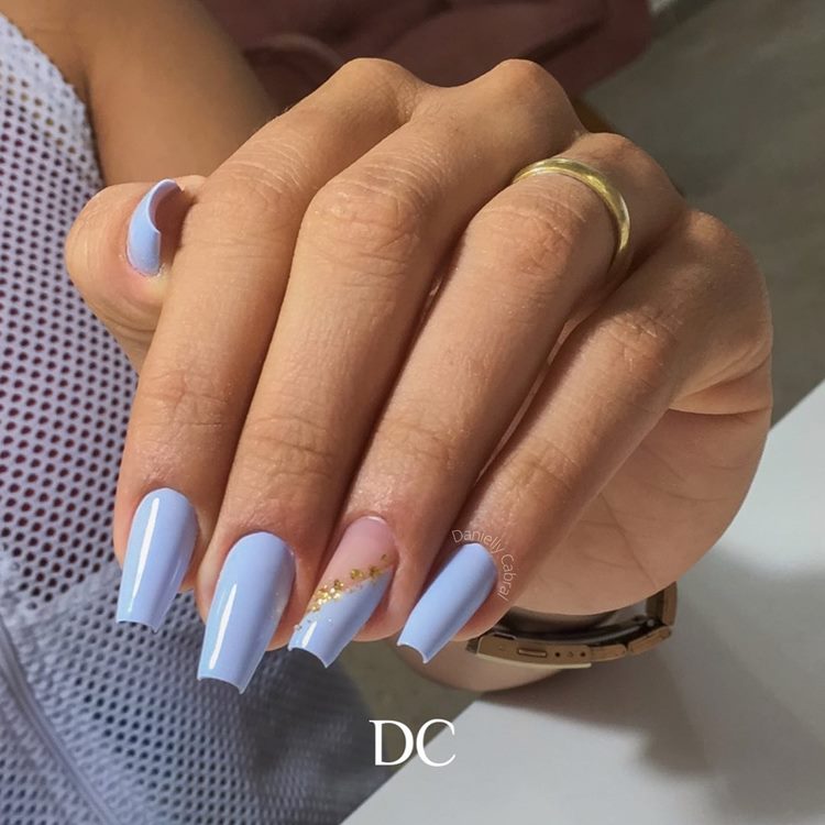Unha azul pastel com filha única divida diagonal separa por partículas de folha de ouro