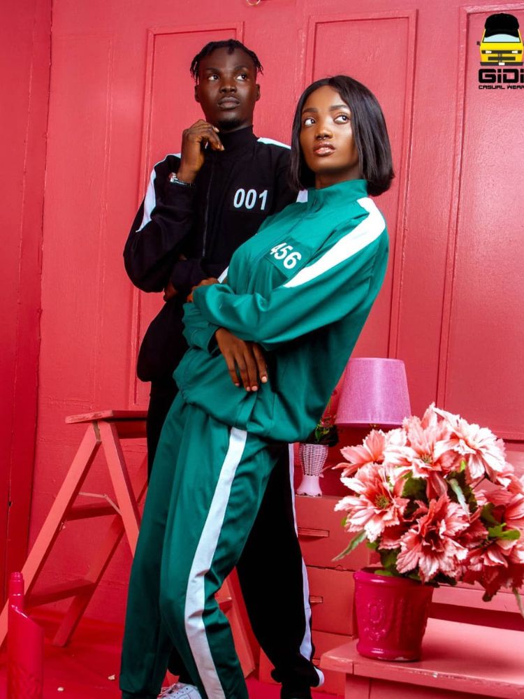 Duas pessoas de pele negra usando uniforme do Round 6, um preto e outro verde 