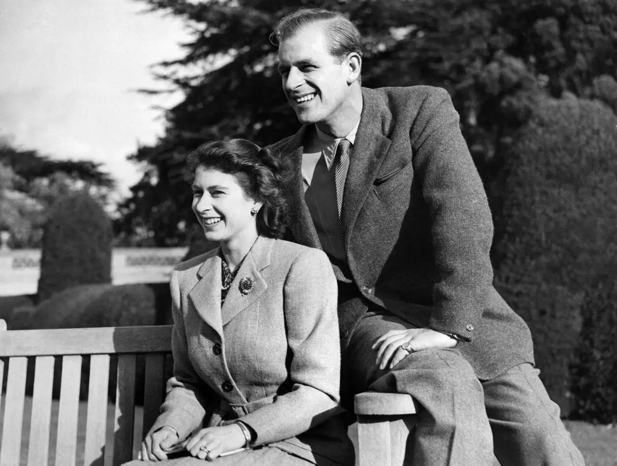 Casal em banco de madeira.