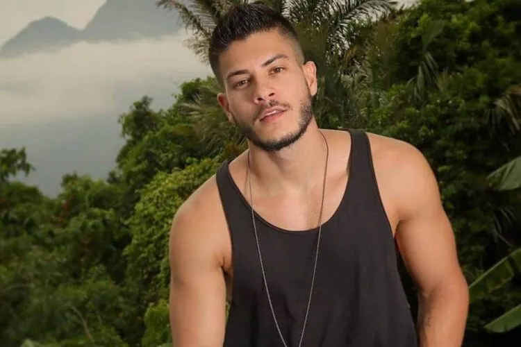 Arthur Aguiar de regata preta em meio a plantas