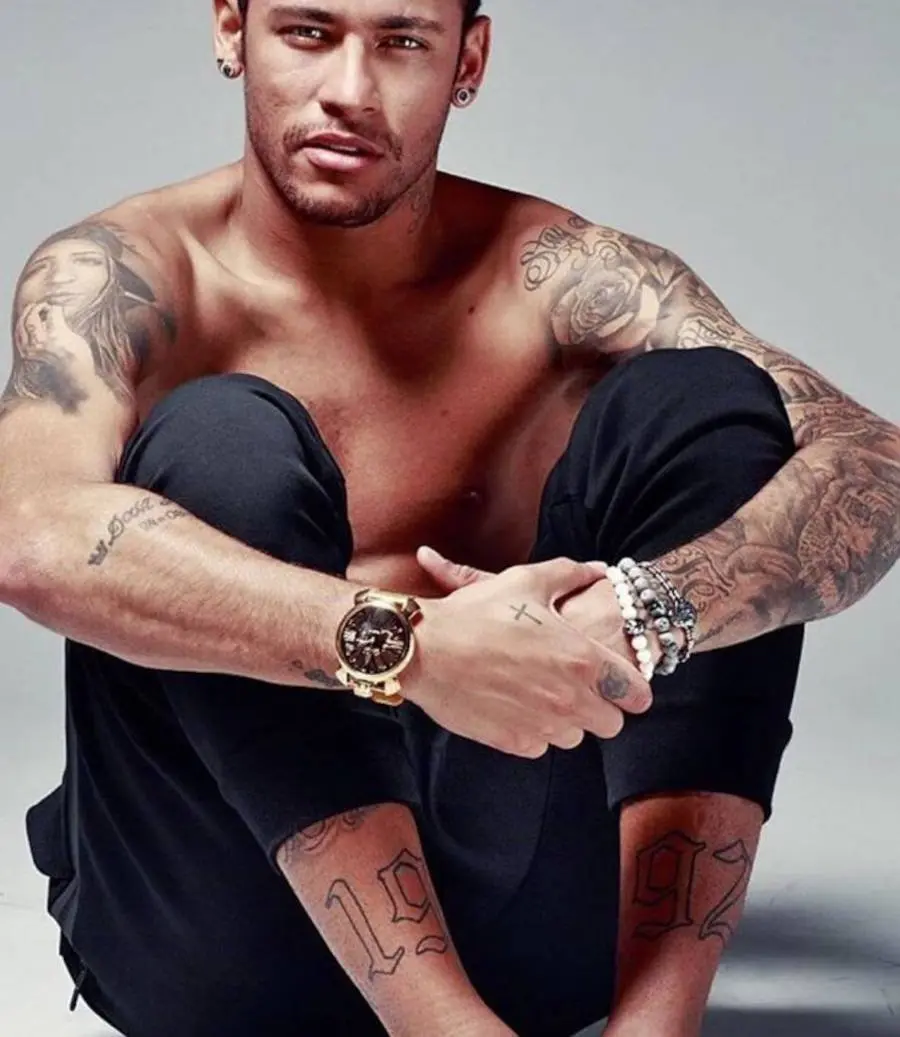 Foto de Neymar abraçado com sua perna mostrando sua tattoo de 1992