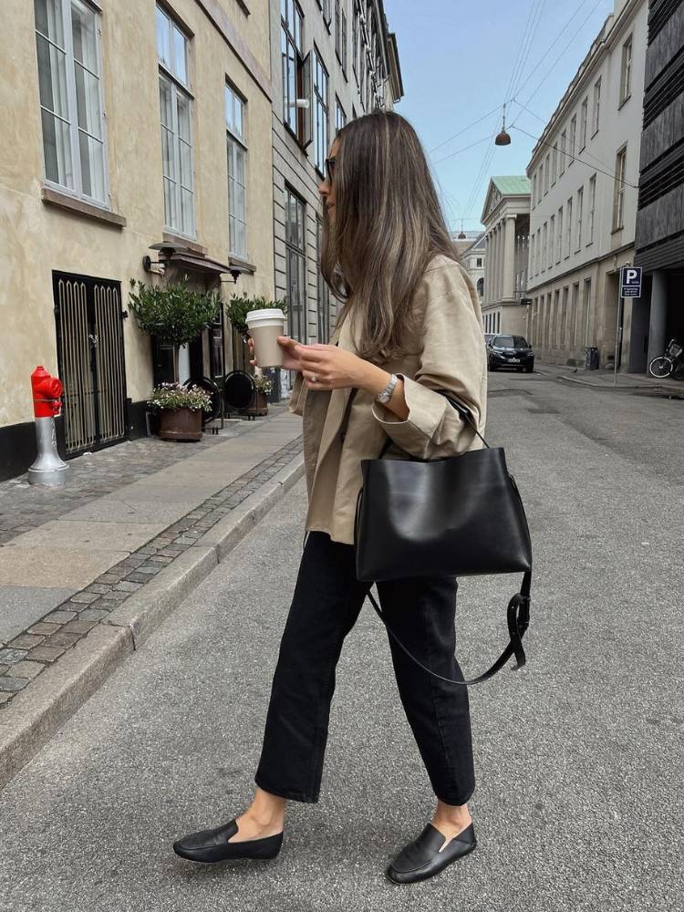 Mulher usando blazer de linho, calça preta e mocassim
