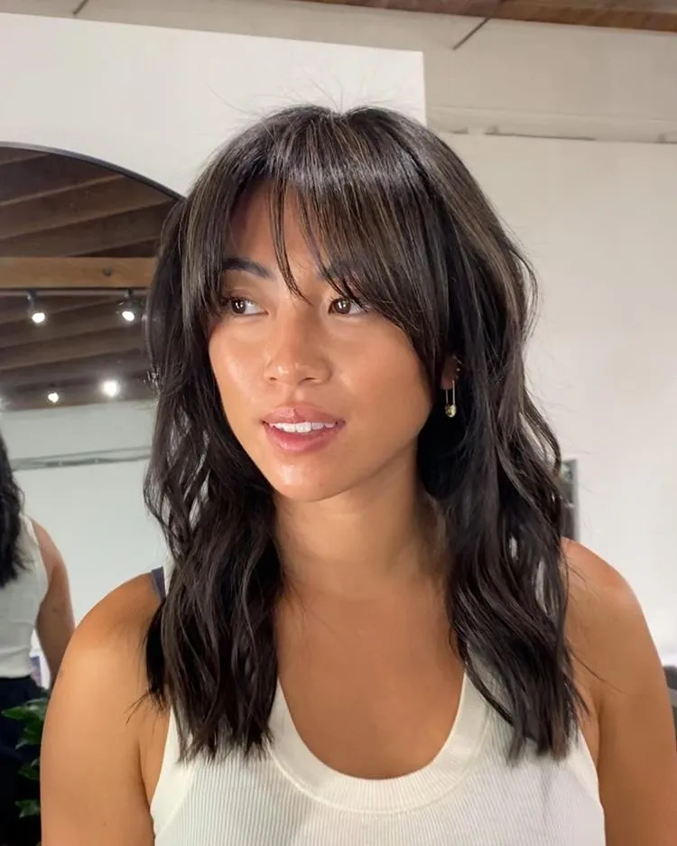 mulher de cabelo médio liso castanho e franja média