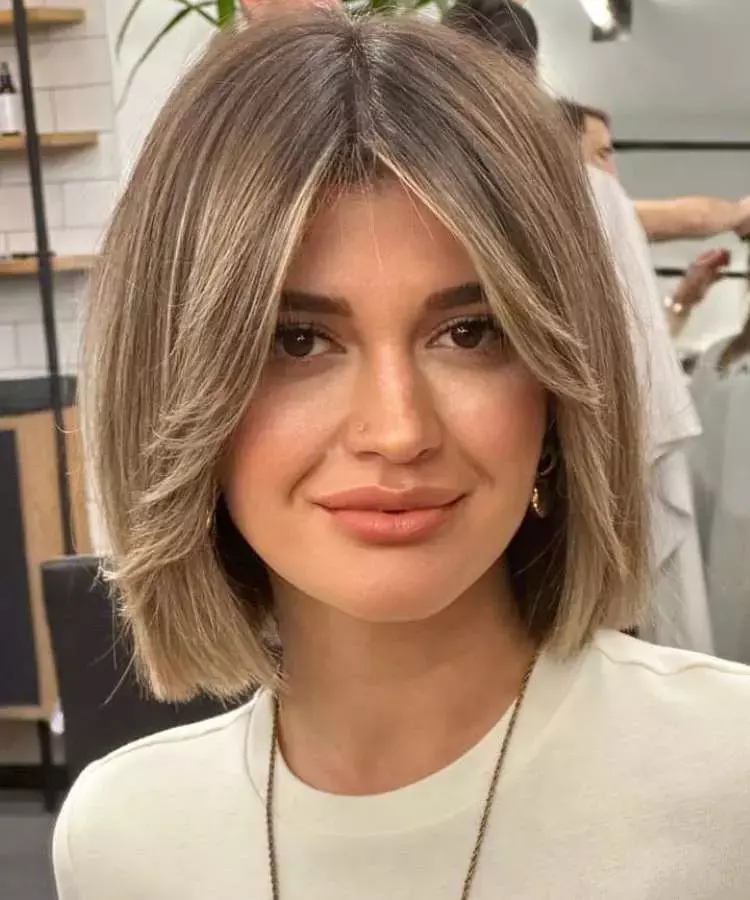 Mulher com corte de cabelo médio franja butterfly luzes liso