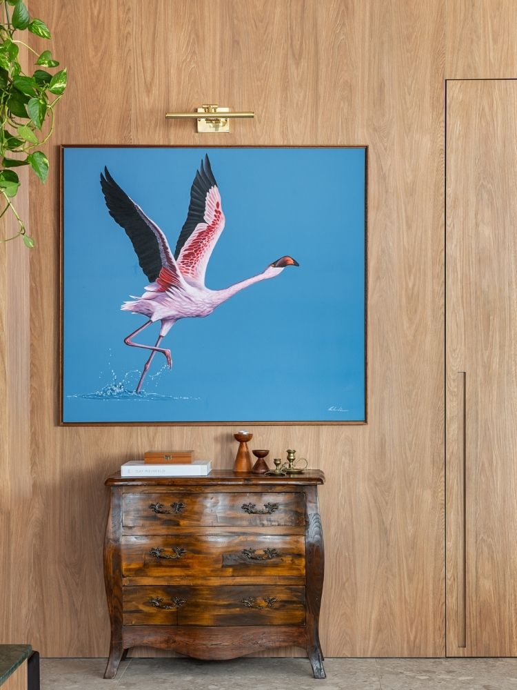 Zoom em parede de madeira com quadro de ave e cômoda vintage