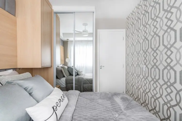 Quarto com papel de parede, cama de casal, armário carvalho e armário com espelho