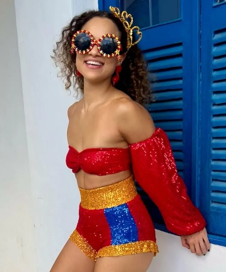 Foto de mulher usando fantasia vermelha com tiara de Carnaval dourada