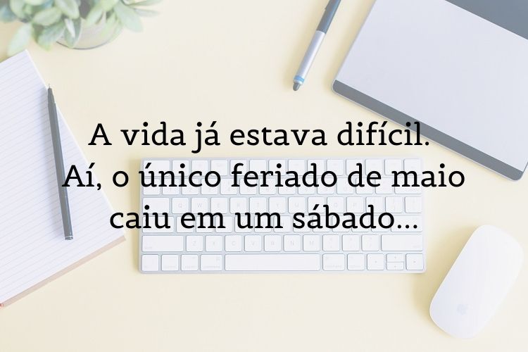 Foto de mesa com mouse, caneta, lápis e caderno, além de frase "A vida já estava difícil. Aí, o único feriado de maio caiu em um sábado…"