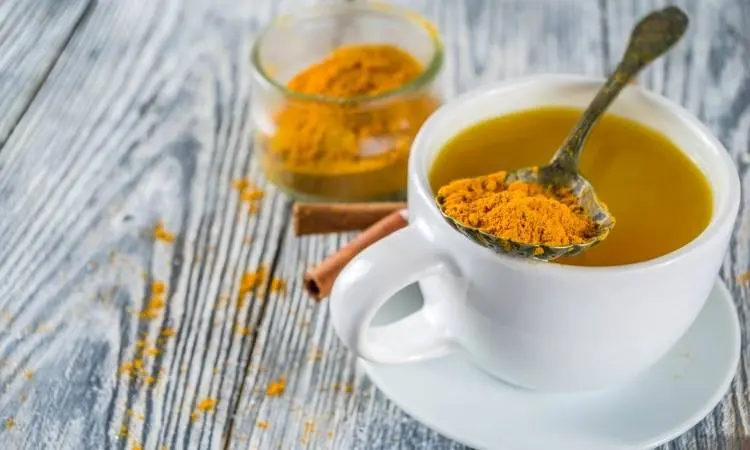 Xícara branca com chá de cúrcuma