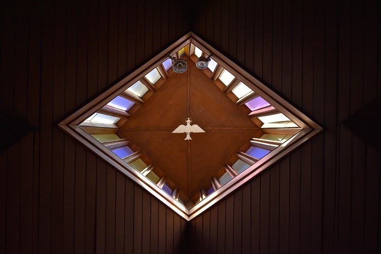 teto de igreja com vitral de pomba branca