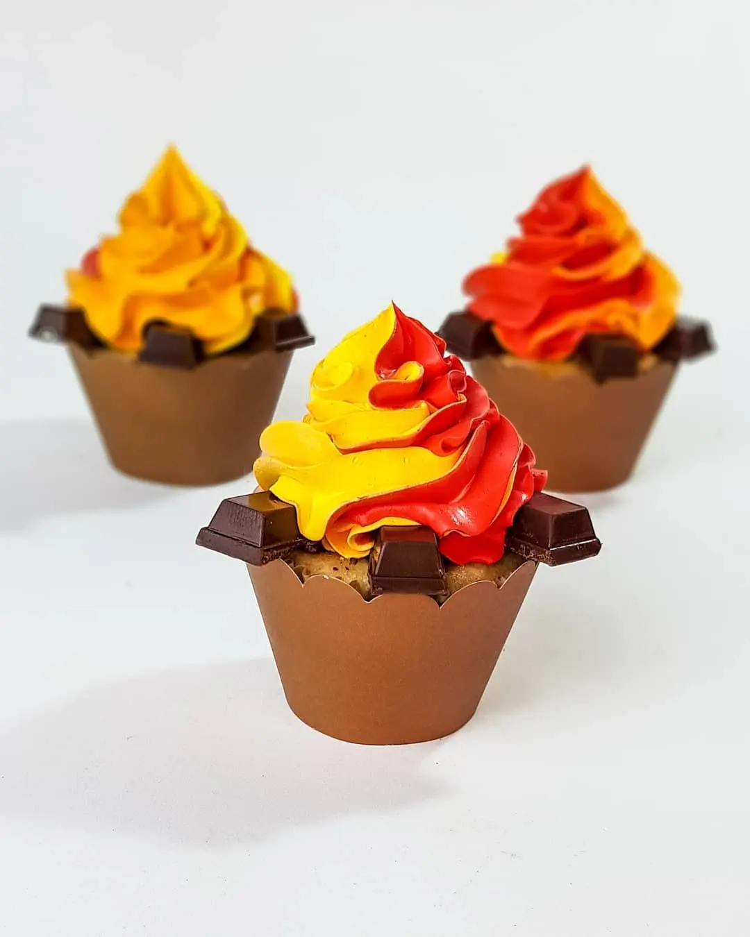 Cupcake para festa junina decorado de fogueira: feitos com chantily e chocolate em barra, cores vermelho,a amarelo e marrom