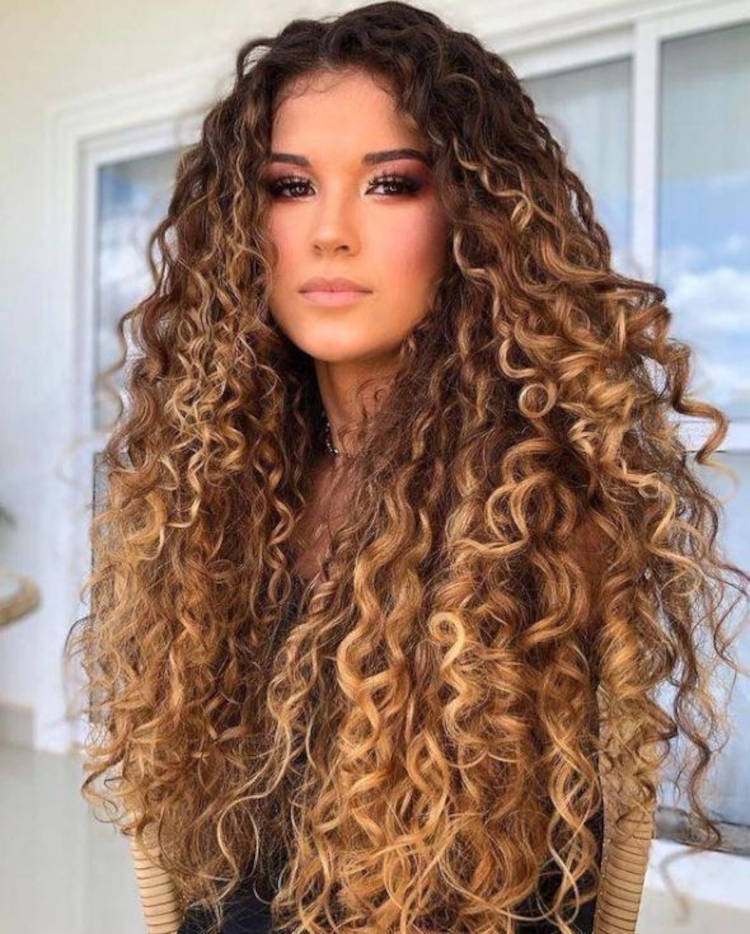 Mulher de pele clara com cabelo cacheado solto