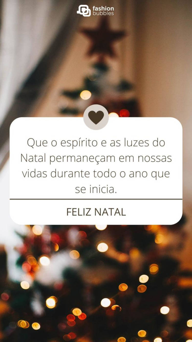 Foto desfocada de árvore de Natal com retângulo branco e frase: Que o espírito e as luzes do Natal permaneçam em nossas vidas durante todo o ano que se inicia.