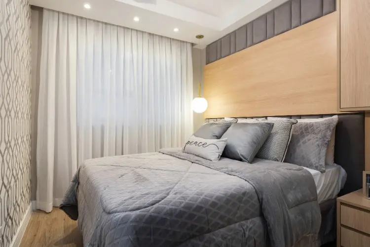 Outro ângulo do quarto, com luminária pendente e cortina