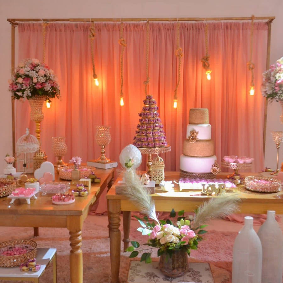 Decoração rosa com duas mesas de madeira.