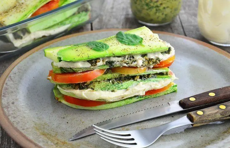 Foto de abobrinha fatiada com tomate, molho e carne 