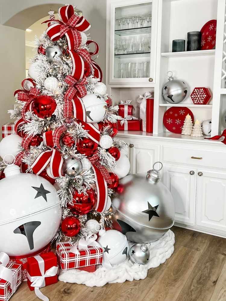 Árvore de Natal branca decorada com laços e bolas vermelhas gigantes