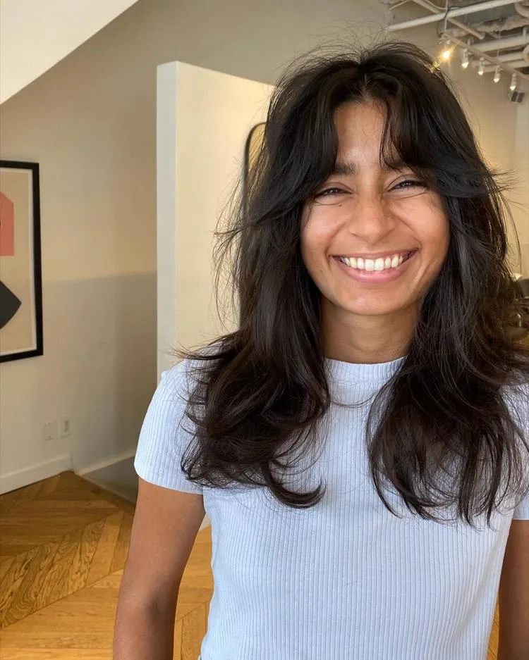 mulher de cabelo médio liso castanho e franja média
