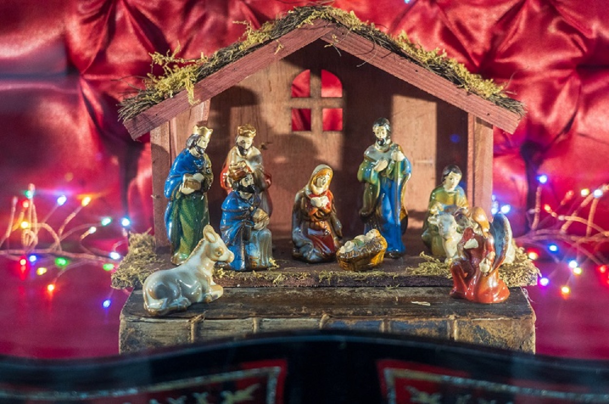 presépio de porcelana iluminado por luzes coloridas