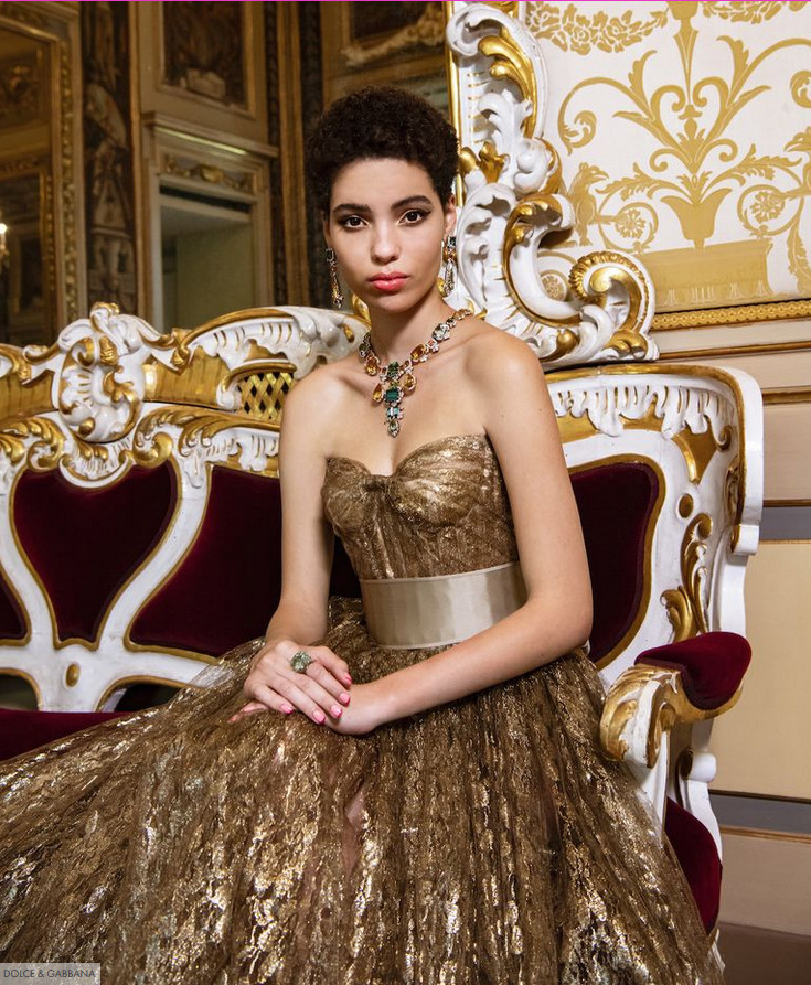 Modelo morena usando maravilhoso vestido dourado pegada dos anos 50 e toque barroco com cinto largo Modelo morena usando maravilhoso vestido dourado