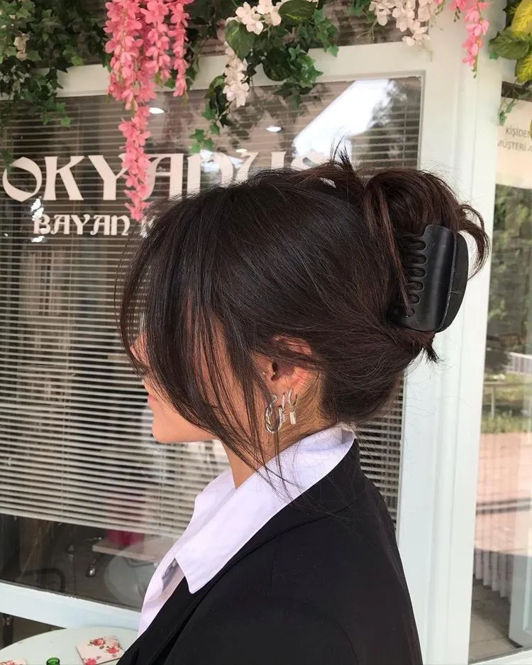 mulher de cabelo preso com presilha e curtain bangs solta