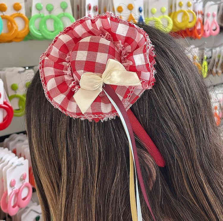 Mini chapéu quadriculado vermelho e branco em cabelo castanho