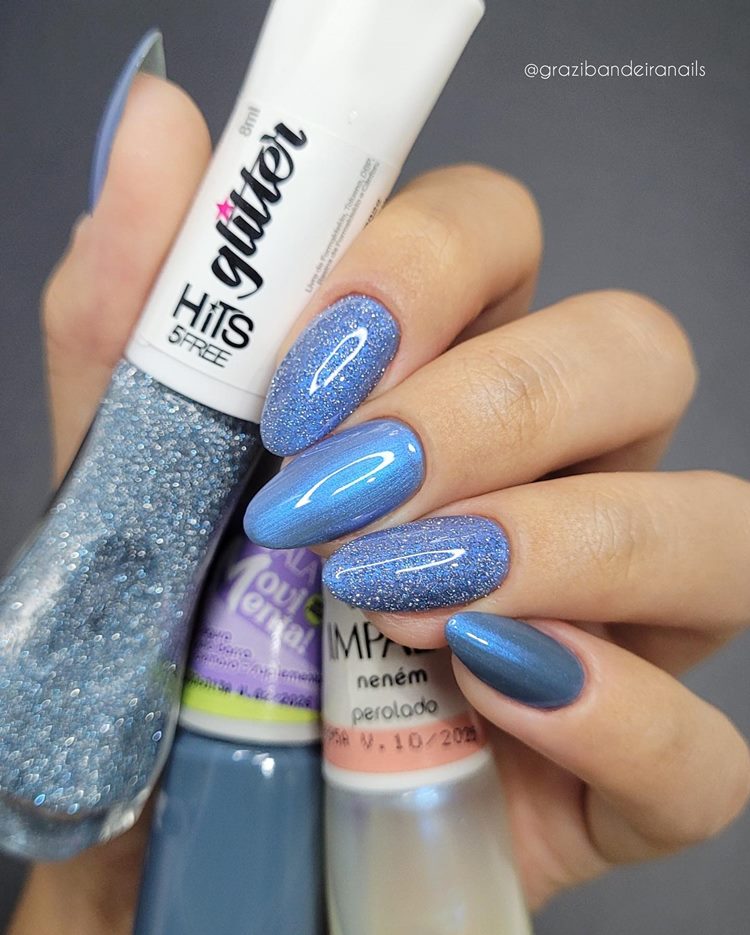 Unhas decoradas em tons de azul com esmalte perolado e glitter