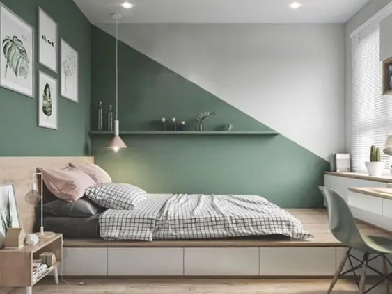 Quarto com cama de casal, parede geométrica verde, quadros, home office e mais