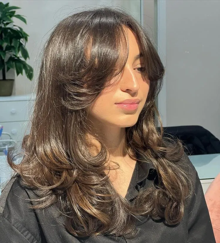 mulher de cabelo médio liso castanho e franja média