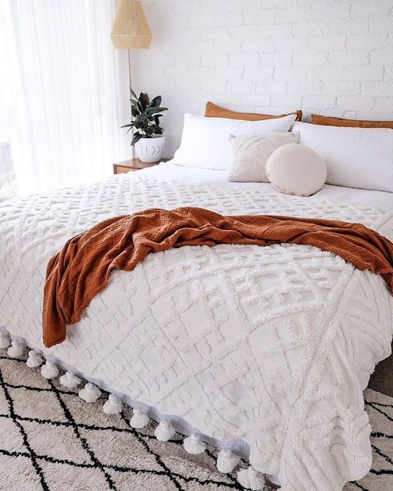 Decoração de outono para quarto, com roupa de cama em bege e marrom