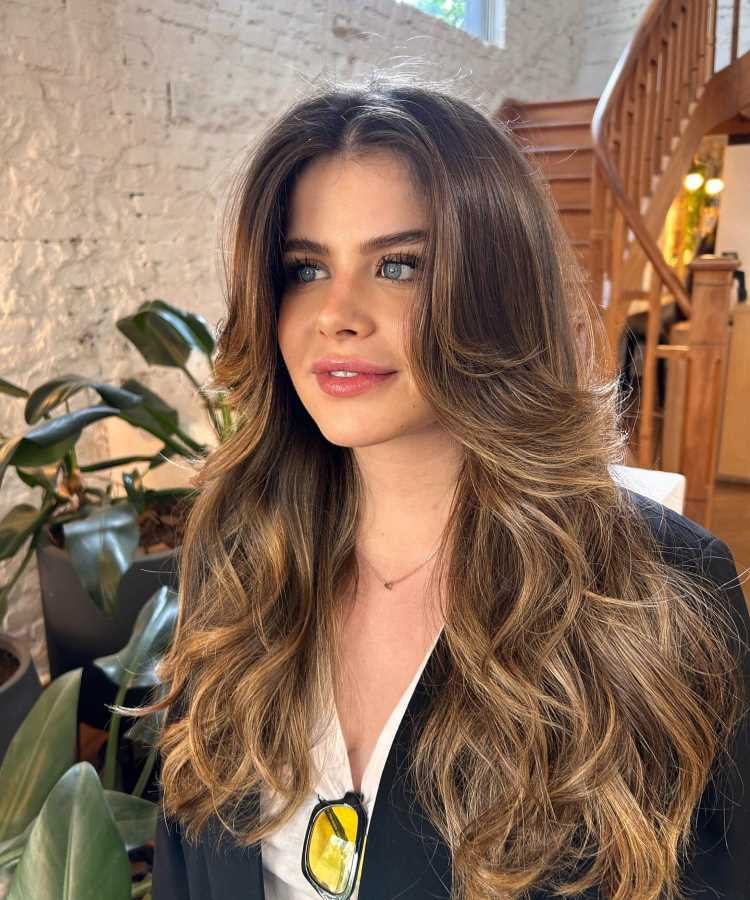 A imagem mostra um corte de cabelo longo com a técnica repicado, conhecido como "corte em camadas" ou "corte repicado em camadas". Esse estilo cria volume e movimento nos fios, e a franja cortina adiciona um toque moderno e elegante ao visual.


