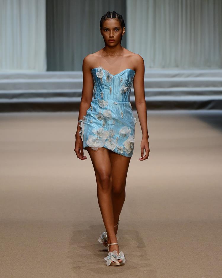 modelo com vestido azul claro com flores brancas