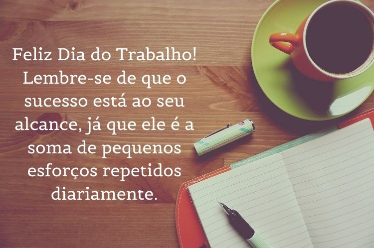 Foto de mesa de madeira, com caderno e xícara de café, além de frase "Feliz Dia do Trabalho! Lembre-se de que o sucesso está ao seu alcance, já que ele é a soma de pequenos esforços repetidos diariamente."