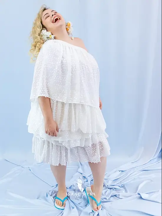 Modelo usa vestido branco um ombro só em camadas