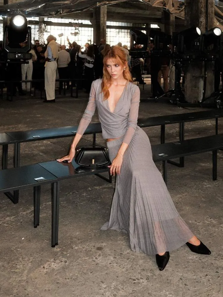 Foto da influenciadora Jordanna Maia usando camisa e saia longa cinzas no desfile da Boss