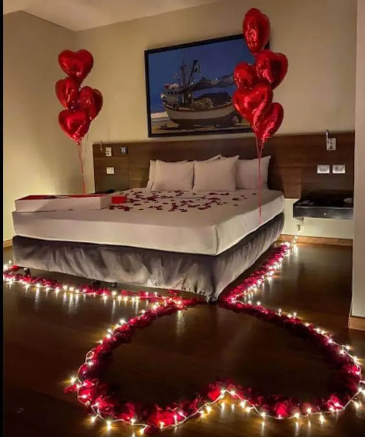 Quarto romântico decorado com velas. Coração com velas no chão em quarto romântico.
