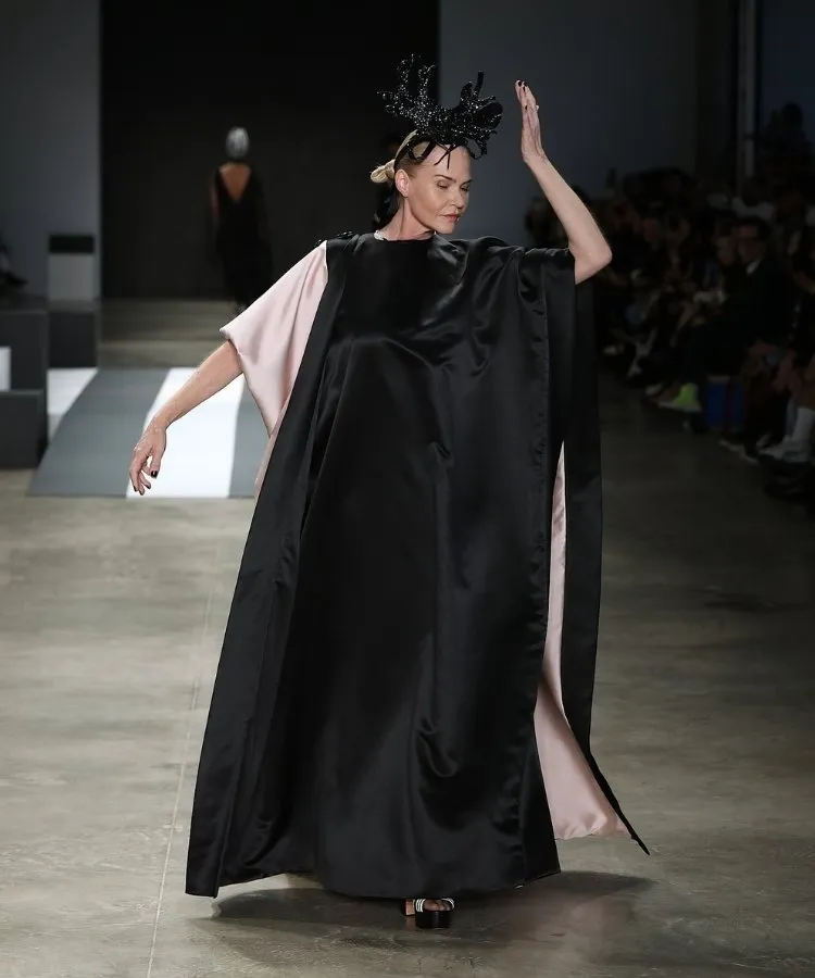 Foto de modelo na passarela usando vestido longo preto