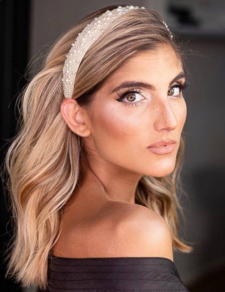 Mulher de pele clara usando cabelo loiro com tiara de pérolas