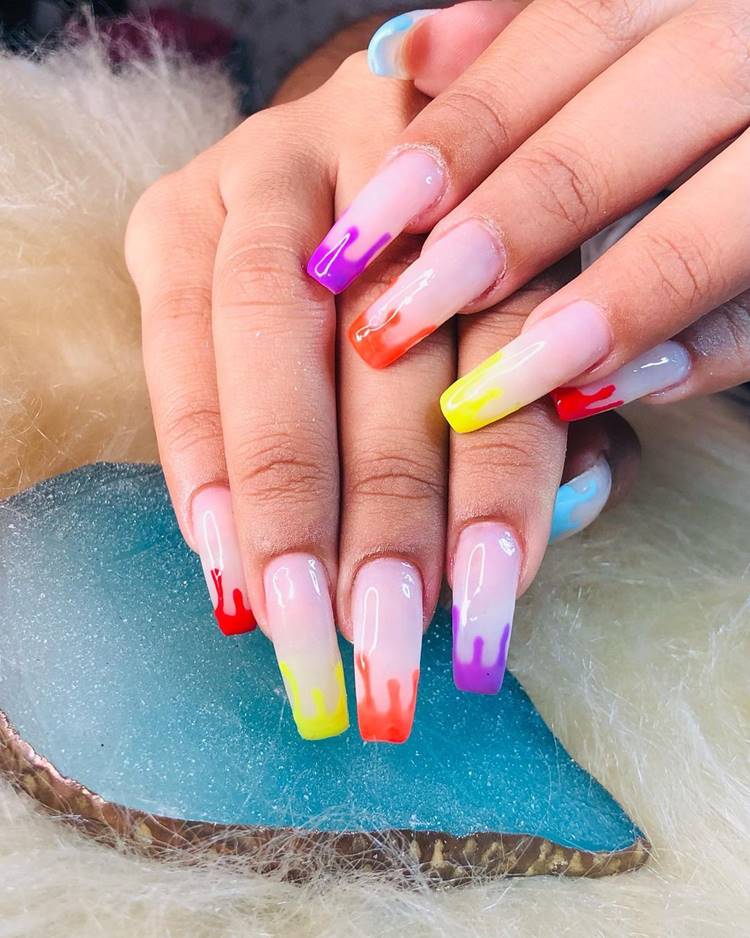 Mão com unhas arco-íris LGBTQIA+: Polegar: rosinha com estilo tinta pingando cor azul claro Indicador: rosinha com estilo tinta pingando cor roxo Médio: rosinha com estilo tinta pingando cor laranja Anelar: rosinha com estilo tinta pingando cor amarelo neon Mínimo rosinha com estilo tinta pingando cor vermelho