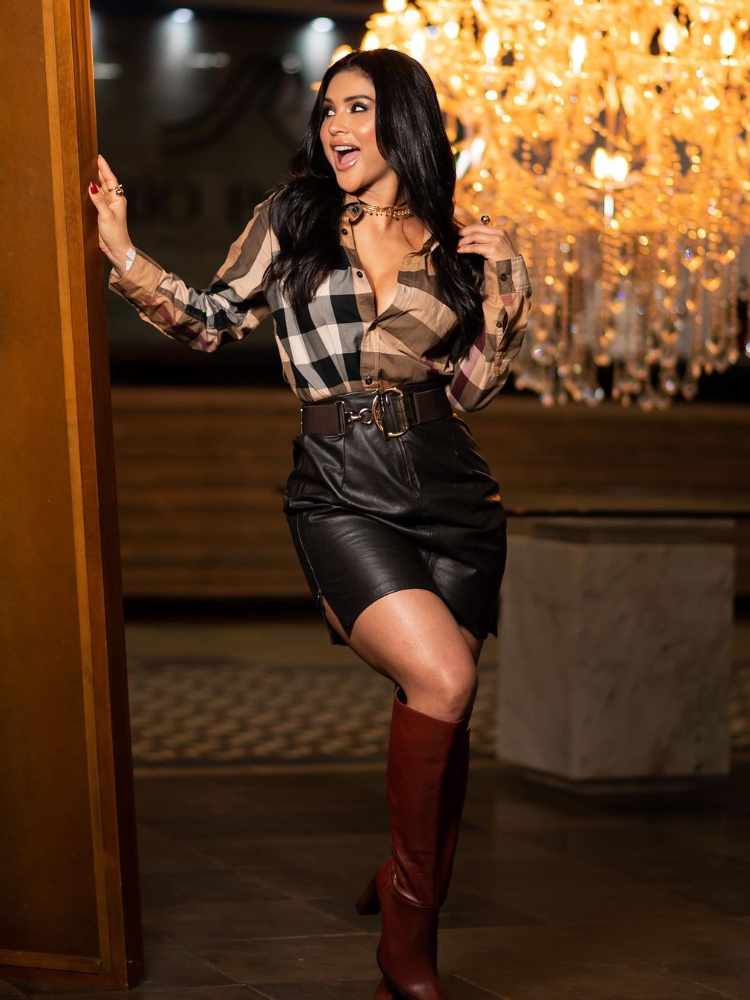 Mileide Mihaille com look pegada junino: camisa xadrez + saia de couro preta + bota de couro marrom