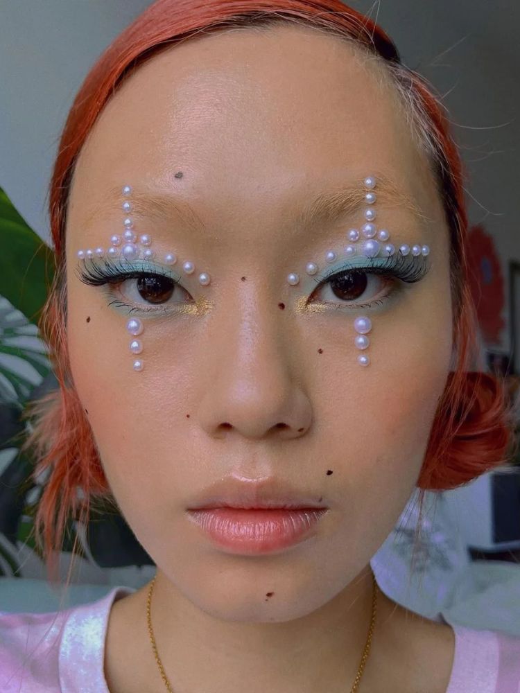 Mulher de origem asiática usando cruz de pérolas nos olhos 