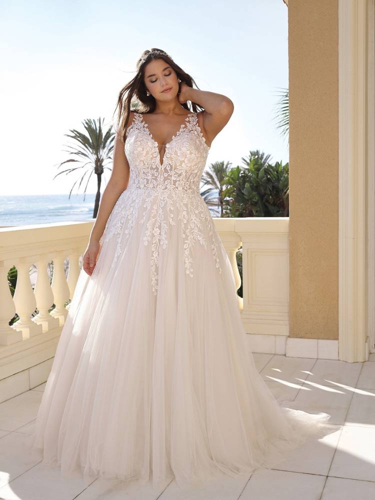Mulher de pele clara usando vestido de noiva com alças e flores bordadas 