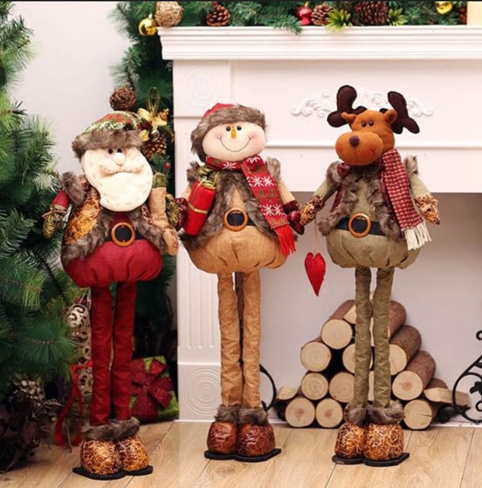 Enfeites de papai Noel, boneco de neve e rena perto de lareira
