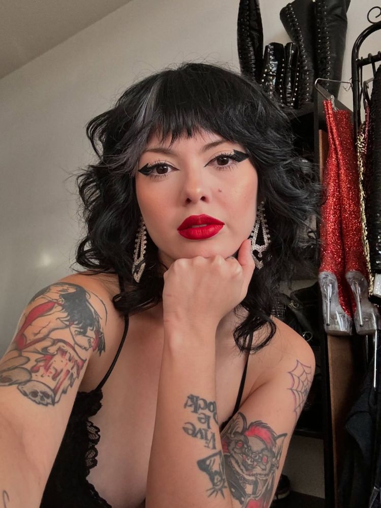 Mulher de pele clara maquiada e com cabelo branco e cinza em shaggy